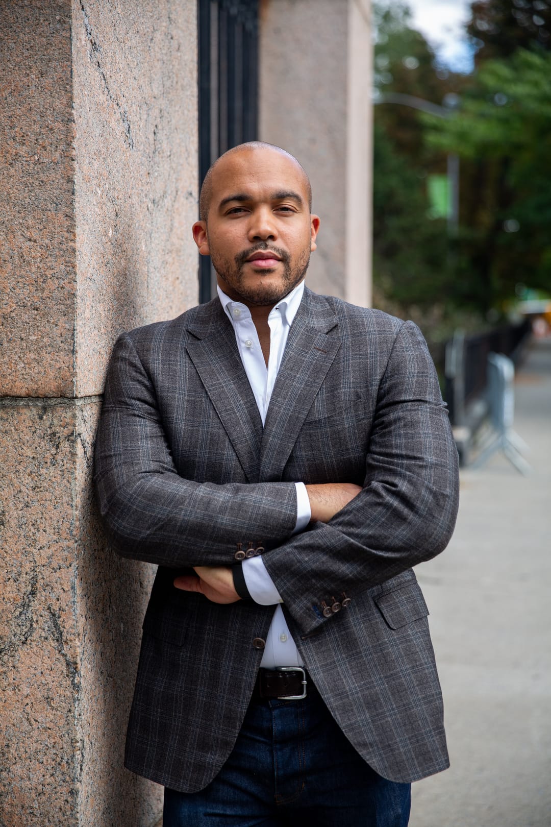 Akili Hinson wearing a blazer, photographed in front of a building
