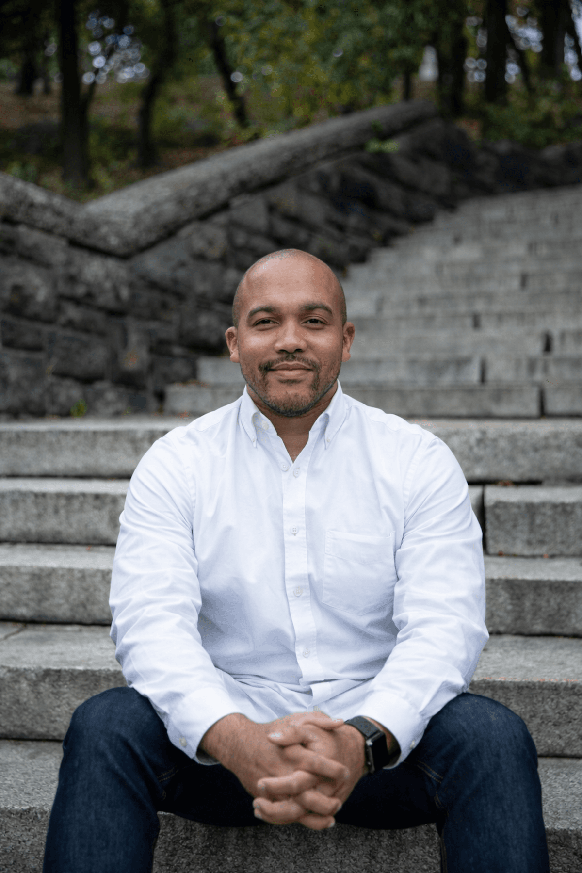 Akili Hinson standing on stone steps, wearing a white shirt